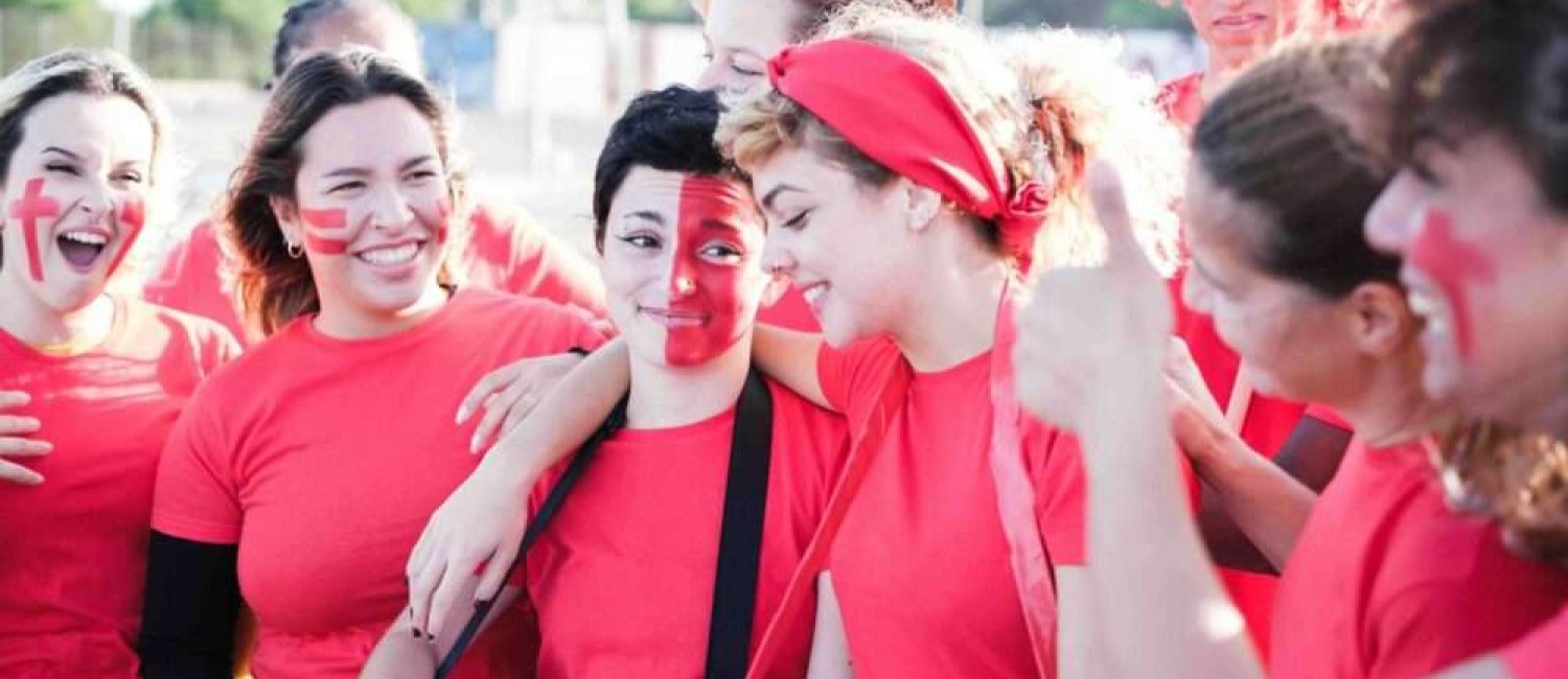 Maschsee Hannover – Eine Gruppe von Menschen in roten Hemden und mit Gesichtsbemalung steht dicht beieinander. Einer spielt Trommel, ein anderer trägt eine rote Perücke. Sie scheinen ein Open-Air-Event zu feiern, vielleicht die ausgelassene Atmosphäre des Drachenbootrennens in Hannover. – maschseefest Hannover Maschsee Hannover - Eine Gruppe von Menschen in roten Hemden und mit Gesichtsbemalung steht dicht beieinander. Einer spielt Trommel, ein anderer trägt eine rote Perücke. Sie scheinen ein Open-Air-Event zu feiern, vielleicht die ausgelassene Atmosphäre des Drachenbootrennens in Hannover. - maschseefest Hannover